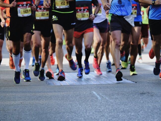 Several marathon runners and their footwear