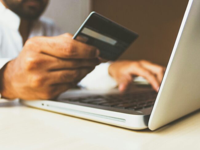 Man with credit card and laptop shopping online