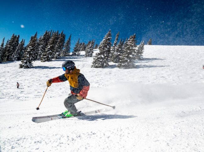 Person in orange ski suit skiing