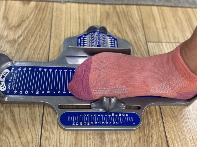 Photo of foot being measured by a Brannock Foot Measuring Device